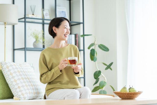 リビングでよもぎ茶を飲みながらくつろぐ女性